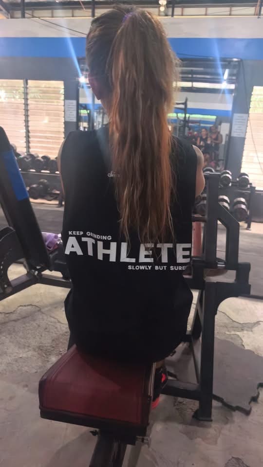 Jasmin seen from behind, sitting at a gym machine